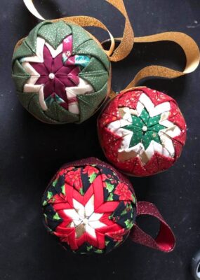 Three fabric ornaments with sparkly ribbon.